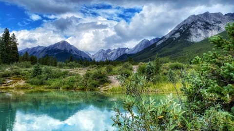 The Ink Pots, mineral springs of blue and green, with mountains in the background