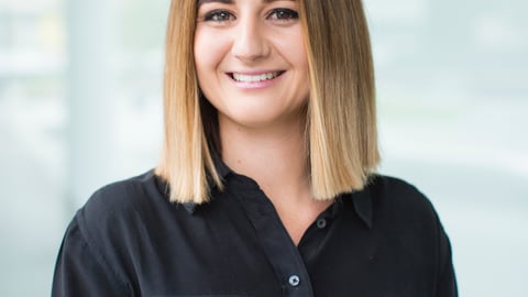 a person wearing glasses and smiling at the camera