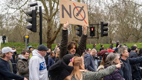 a group of people crossing a street in front of a crowd