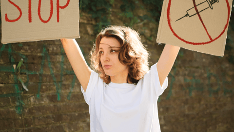 a person holding a sign posing for the camera