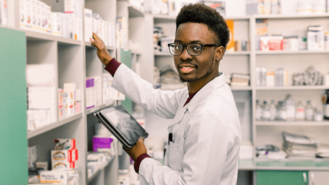 young male pharmacy technician checking stock