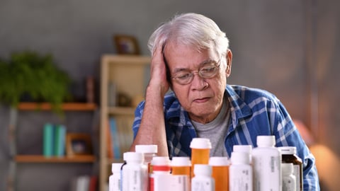 a man sitting at a table with pill bottles in front of him