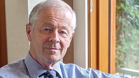 a man wearing a suit and tie looking at the camera