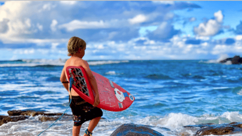 a man carrying a surf board on a body of water