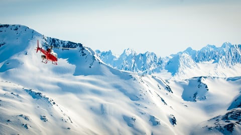 a group of people standing on top of a snow covered mountain