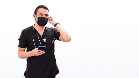 Doctor wearing black scrubs listening to headphones