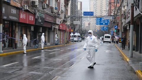 People in hazmat suits in the street in China