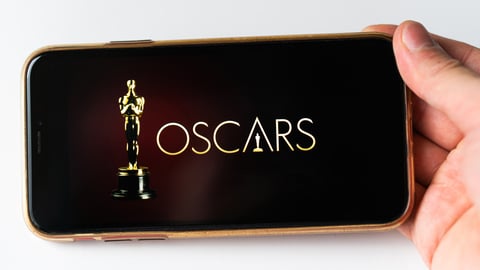 Someone holding a smartphone with the Oscars playing