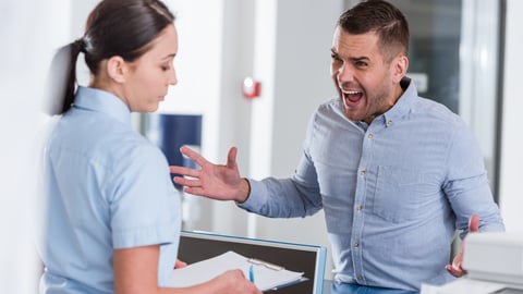 Angry male patient with female healthcare worker.