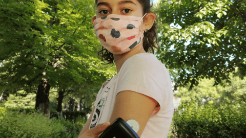 masked girl with diabetes sensor