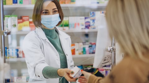 pharmacist handing patient medicine 