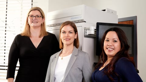 Three women standing smiling