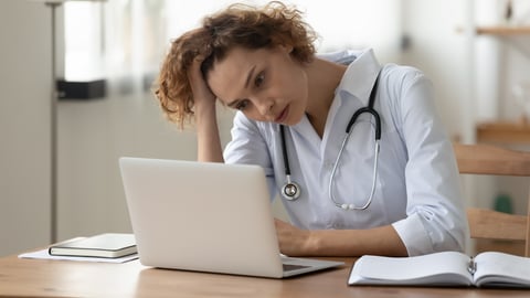 Woman doctor looking frustrated at her computer