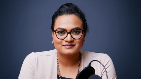 Young south Asian woman with glasses wearing a pink top