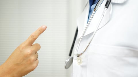 Patient wagging their finger at their doctor