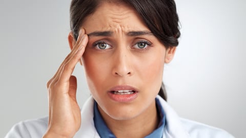 Woman looking exasperated, holding the side of her head