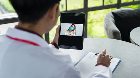 Doctor speaking to a patient on a tablet 