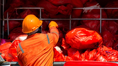 man throwing medical waste in industrial bin