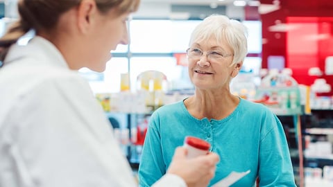 a pharmcist in a store gives advice to a senior woman