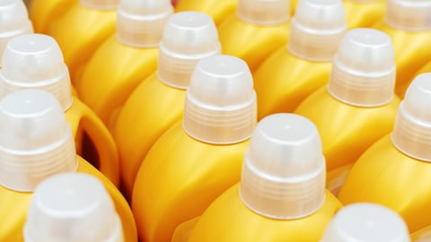 Group of yellow plastic bottles of laundry detergent 