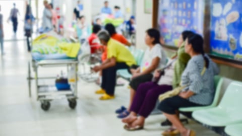 patients on chairs waiting in hospital, one patient on stretcher