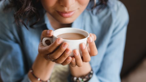 Young woman holding a cup of tea to her lips