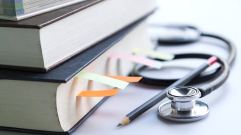 pile-of-books-with-stethoscope-pencil