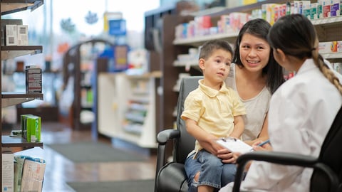 a mother and young child discuss their health with a pharmacist