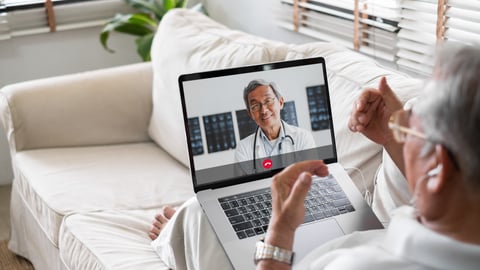 Older man having a virtual doctor's appointment on a laptop