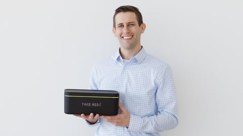 a man holding a technologically advanced pill box