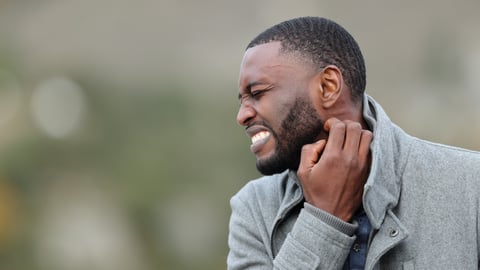 Young Black man scratching his neck