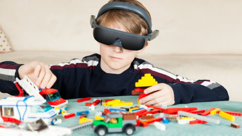 little-boy-wearing-eSight-goggles-playing-Lego