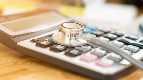 close up of a stethoscope on a calculator