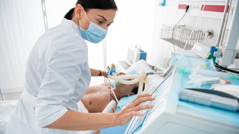 a healthcare worker helping a child with a breathing tube 