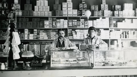 Two men in a Victorian-era grocer