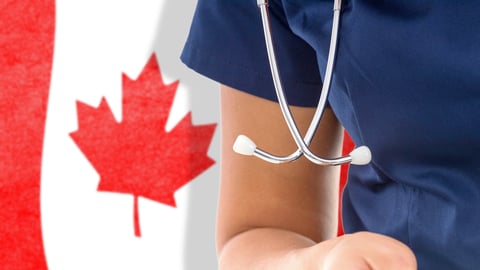 Arm of a healthcare worker in the foreground with a Canadian flag behind