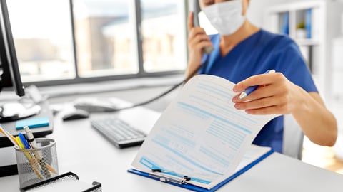 nurse looking at paper charts