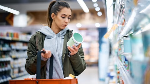 Young woman looking at food labels in the store