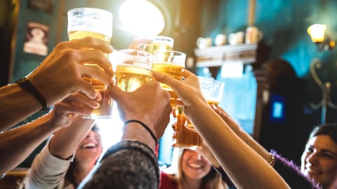 Group of hands raising beer glasses for a toast