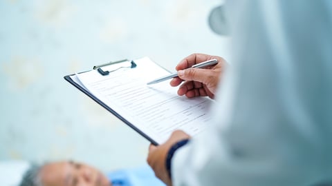 medical professional taking notes on clipboard