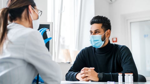 Doctor chatting with young man patient