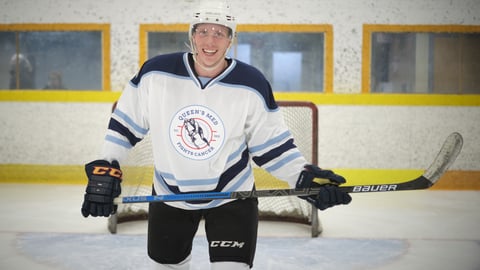 Man in hockey gear on the ice holding a hockey stick