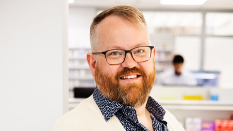 Man in lab coat and glasses smiling