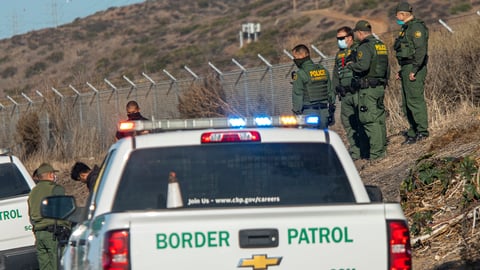 Back of a white pick-up truck with Border Patrol written on the back in green lettering