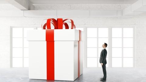 man-looking-at-big-white-box-with-red-bow