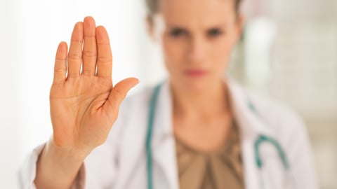 white-female-doctor-with-stethoscope-hand-raised