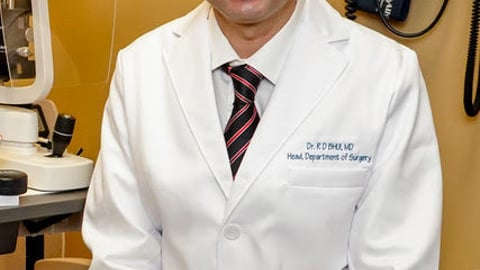 Smiling male doctor in front of medical equipment