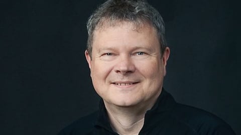 man-against-dark-background-smiling-at-camera