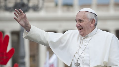 Pope Francis wearing white, waving to a crowd