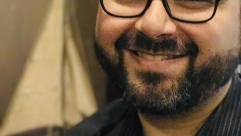 Male doctor with a beard and glasses smiling